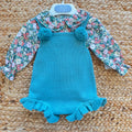 Completo bimba con salopette in maglia verde petrolio e camicia floreale a maniche lunghe