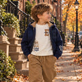 Bambino con felpa blu e maglia panna stile college