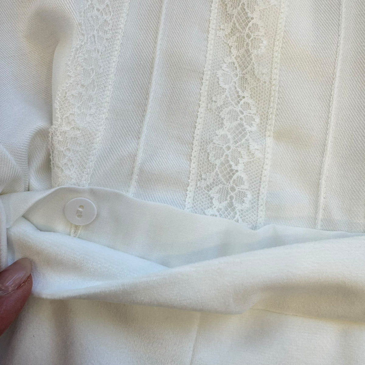 Completo battesimo neonato bianco con camicia a maniche lunghe decorata in pizzo floreale, papillon e pantaloncino a palloncino.