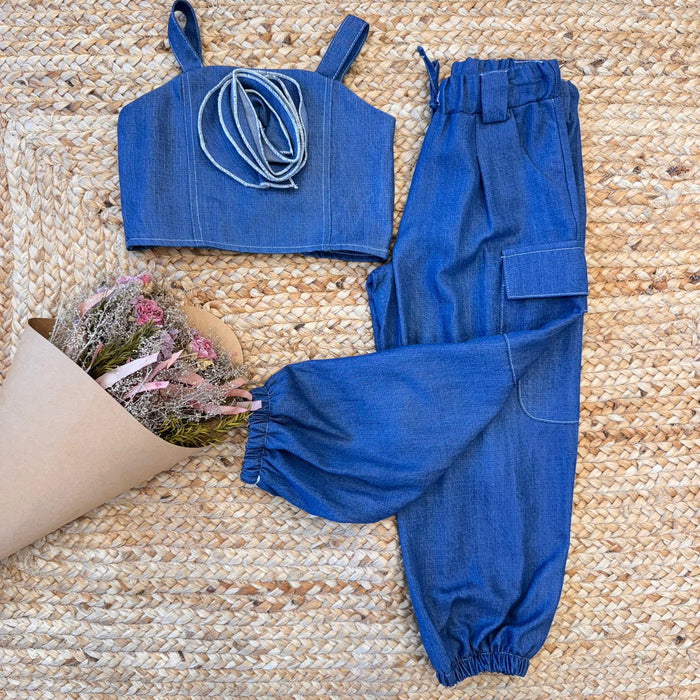  Completo chambray bambina con top e pantaloni cargo su fondo naturale

