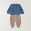 
Completo neonato in cotone e lana con maglia petrolio a trecce e pantalone beige indossato