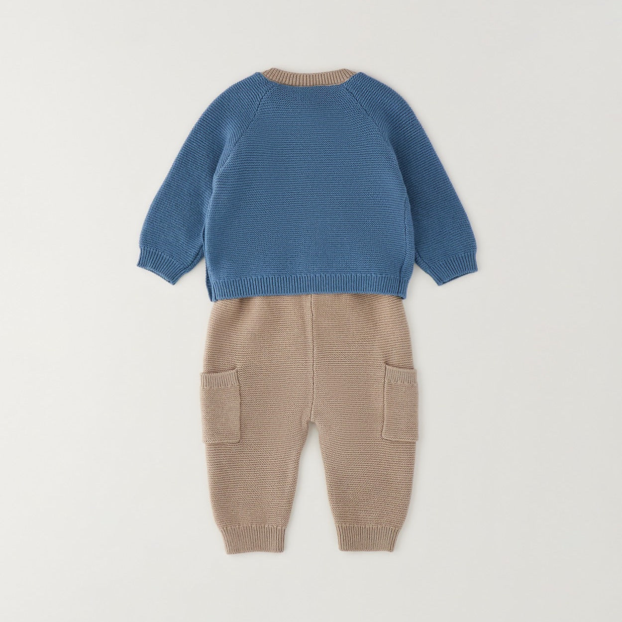 
Completo neonato in cotone e lana con maglia petrolio a trecce e pantalone beige indossato