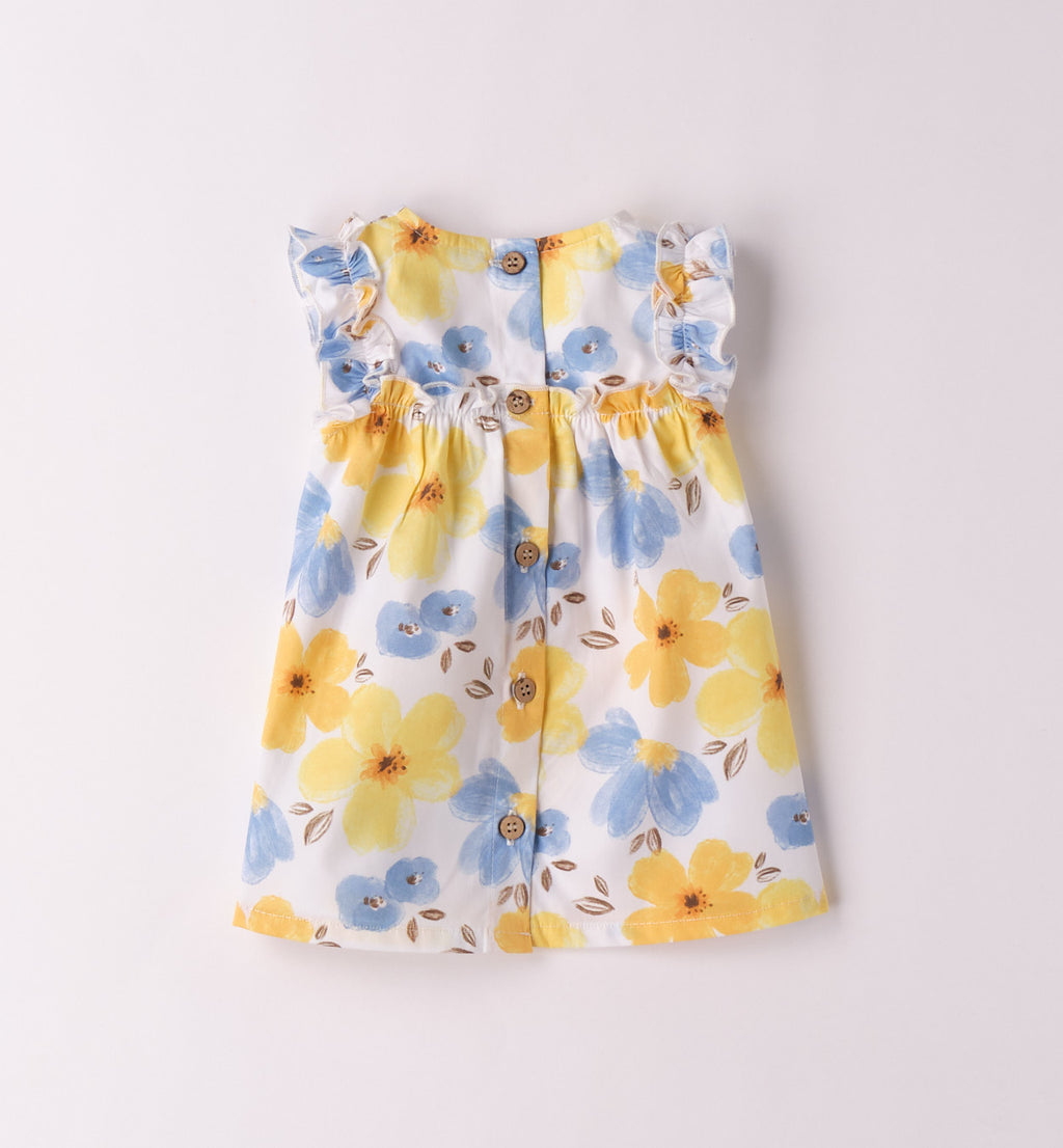 Dettaglio del vestito estivo per bambina con volant e stampa floreale vivace.