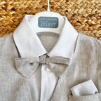 Dettaglio della camicia bianca e del papillon in lino beige coordinato.