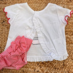 Costume slip a righe rosse con fiocco e t-shirt con stampa barchetta per bambina.