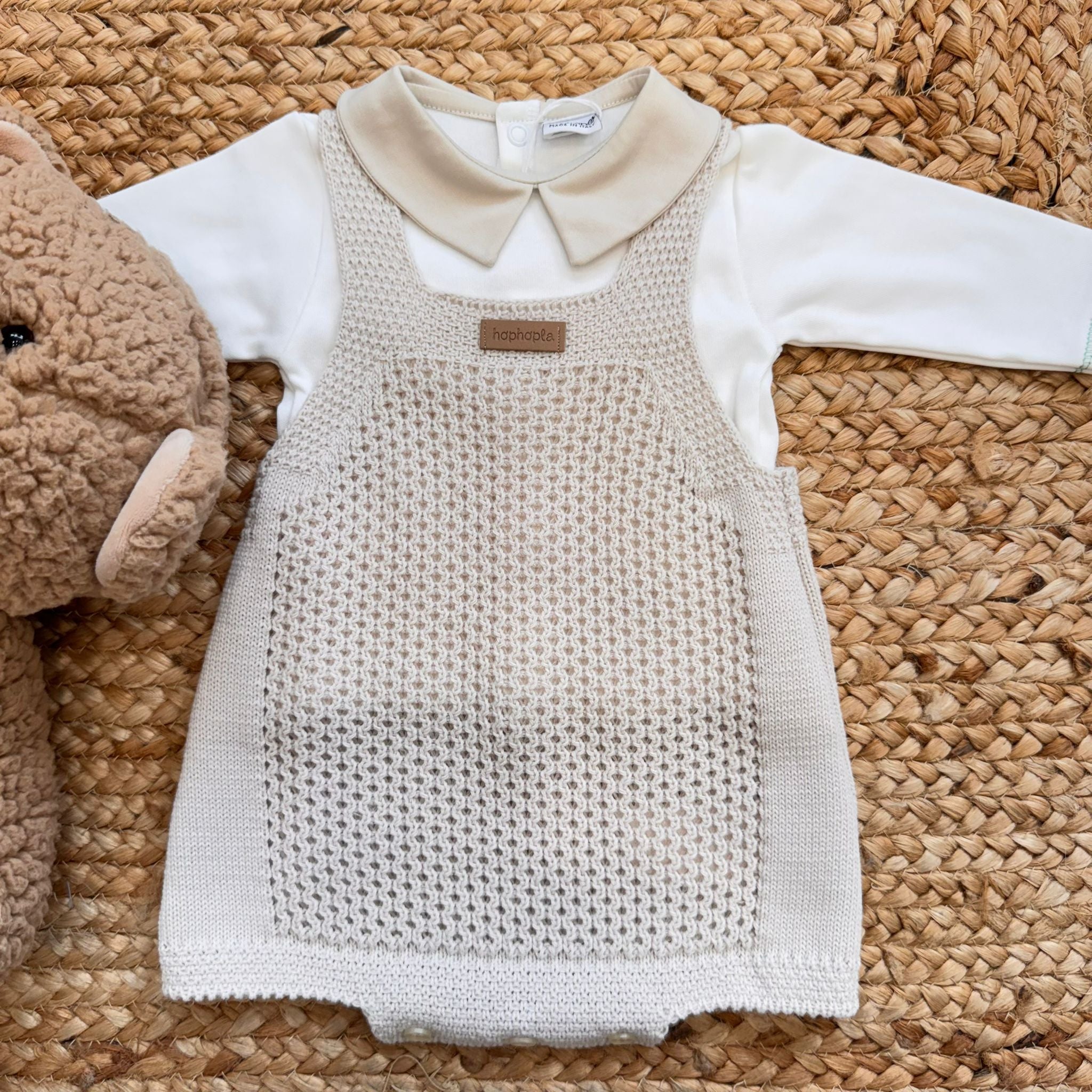 Coordinato neonato beige con salopette e colletto, accanto a peluche