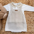 Coordinato neonato beige con salopette e colletto, accanto a peluche