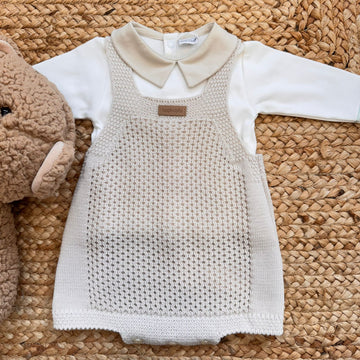 Coordinato neonato beige con salopette e colletto, accanto a peluche
