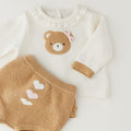 Dettaglio completo neonata cotone e lana con orsetto, fiocco rosa e culotte con cuori