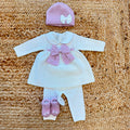 Uscita clinica neonata in pura lana bianca con fiocco rosa e copertina coordinata.