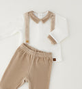 Dettaglio completo neonato in ciniglia con colletto beige e bretelle decorative a righe