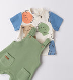 Dettaglio t-shirt con stampa faccine colorate e salopette verde in tessuto lavorato.