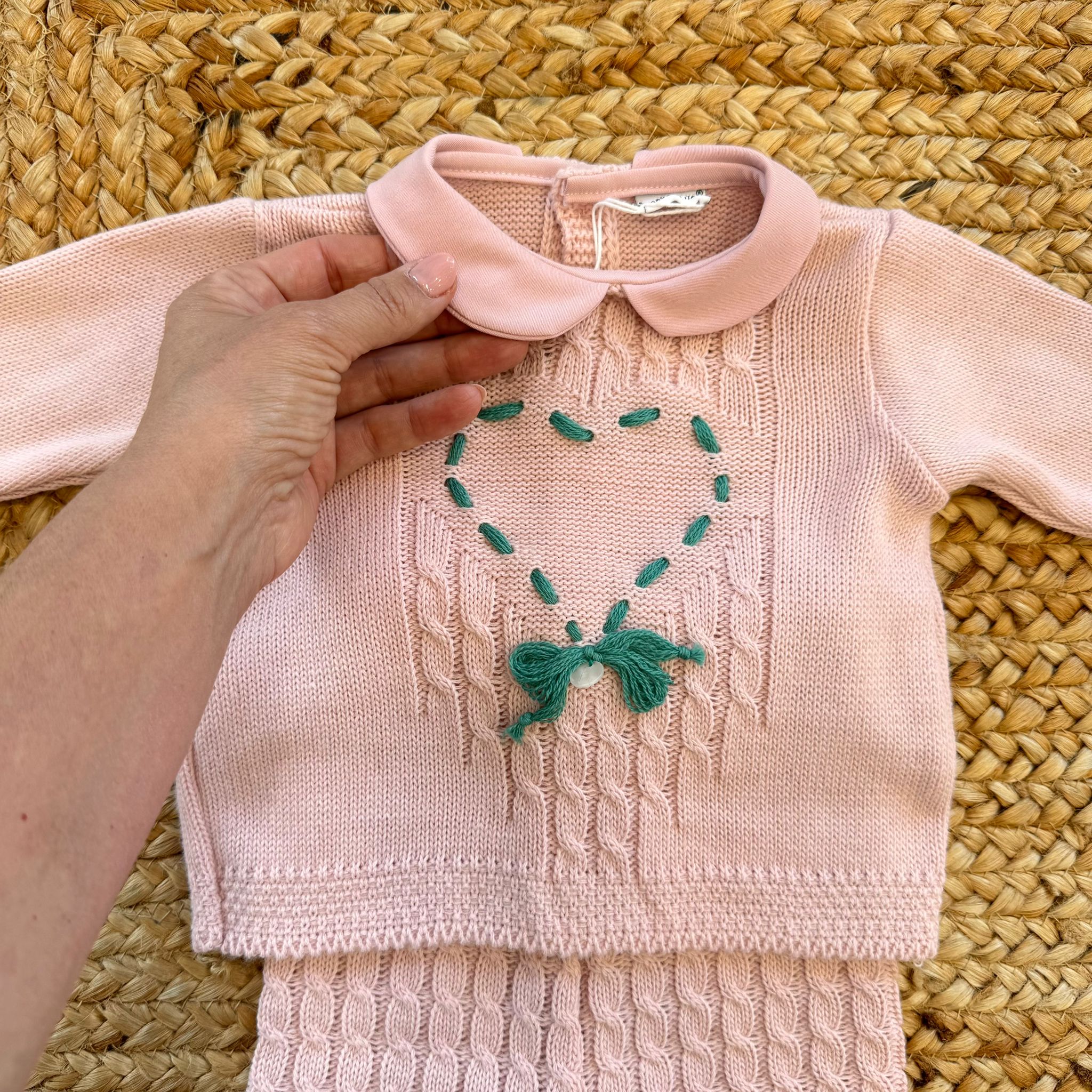 Primo piano del cuore ricamato e del colletto rosa del completo in maglia per neonata – perfetto per nascita o primo cambio