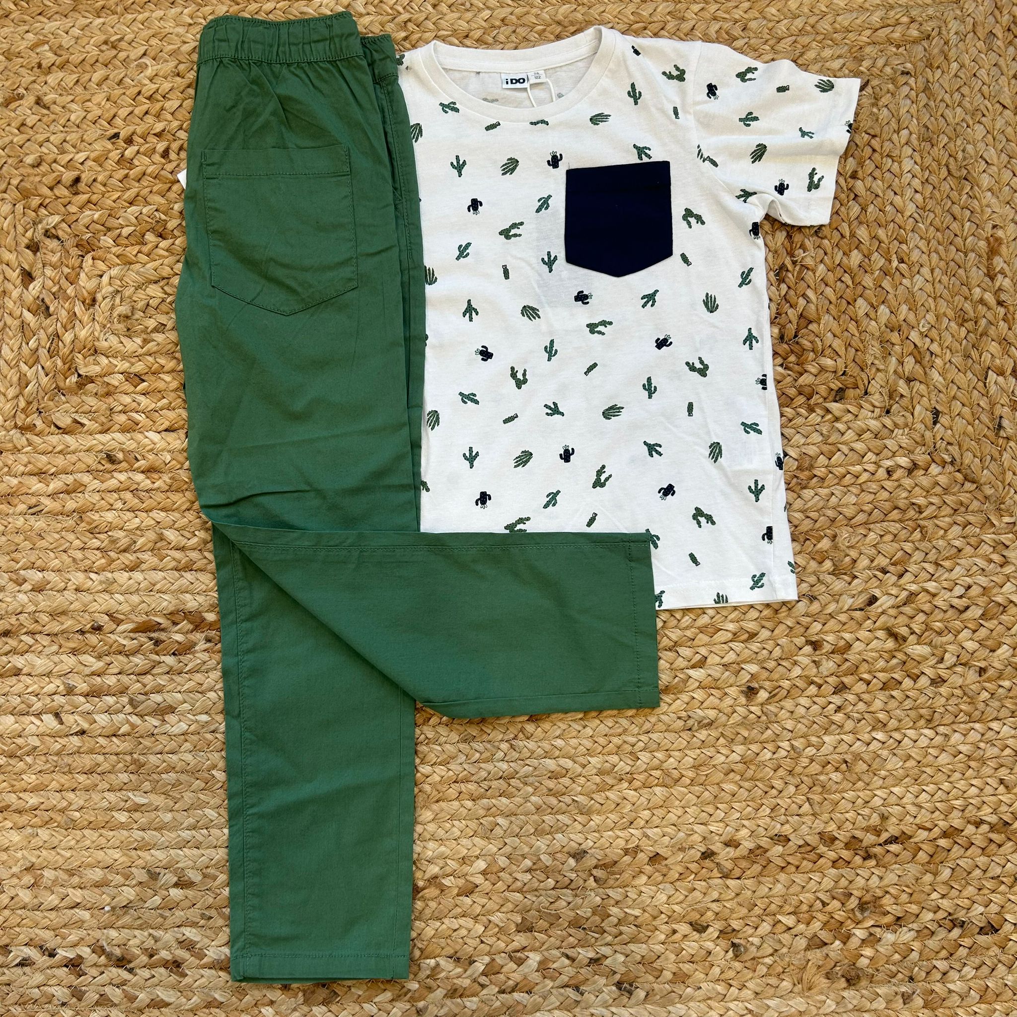 Completo estivo iDO per bambino: t-shirt cactus con taschino blu e pantaloni verdi comodi. Fresco e divertente per l’estate.