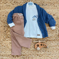 completo bambino con cardigan blu in maglia, t-shirt bianca stampata e pantalone beige