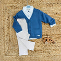 completo elegante bambino con camicia bianca fantasia, cardigan blu e pantalone beige