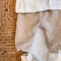 Vista completa del coordinato beige per neonato con tutti gli accessori