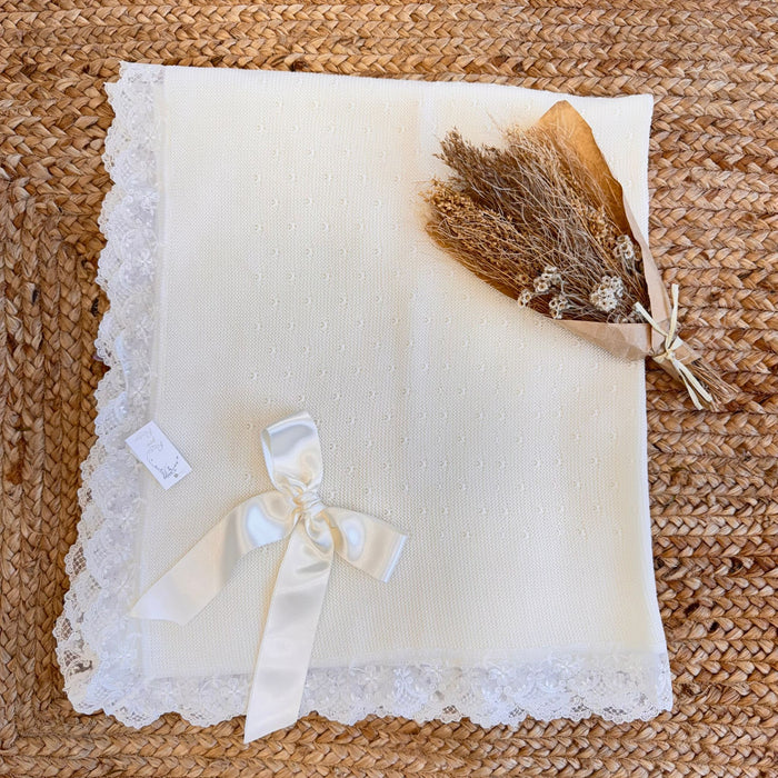 Copertina da battesimo in maglia panna con pizzo e fiocco in raso.