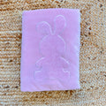 Copertina neonata in ciniglia rosa con grande coniglietto applicato tono su tono, ideale per culla, corredino e set nascita.