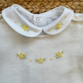 Uscita clinica neonata in pura lana bianco latte con tutina, copertina, cappellino e scarpette con fiorellini gialli.