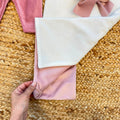 Uscita clinica neonata in ciniglia bianca e rosa con completino ricamato a cuore floreale, fiocco applicato, cappello, bavetta, scarpine, lenzuola coordinate e copertina sfoderabile.