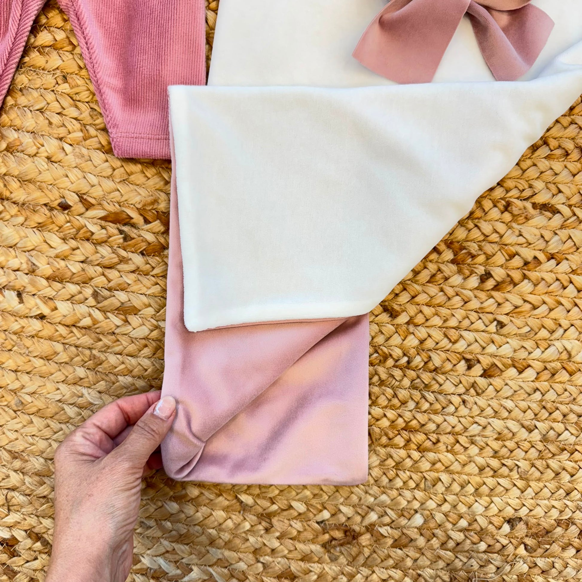 Uscita clinica neonata in ciniglia bianca e rosa con completino ricamato a cuore floreale, fiocco applicato, cappello, bavetta, scarpine, lenzuola coordinate e copertina sfoderabile.