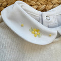 Uscita clinica neonata in pura lana bianco latte con tutina, copertina, cappellino e scarpette con fiorellini gialli.