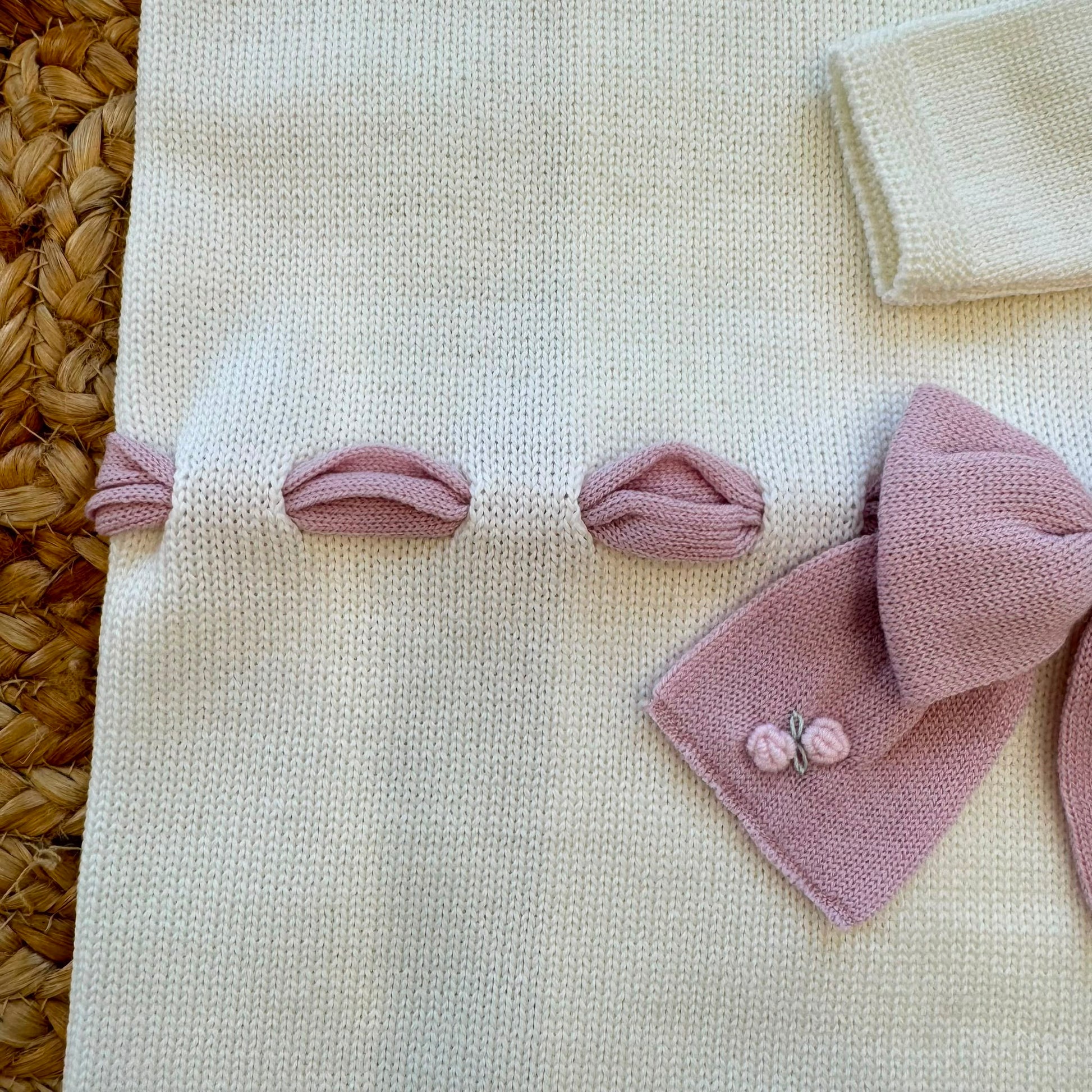 Uscita clinica neonata in pura lana bianca con fiocco rosa e copertina coordinata.