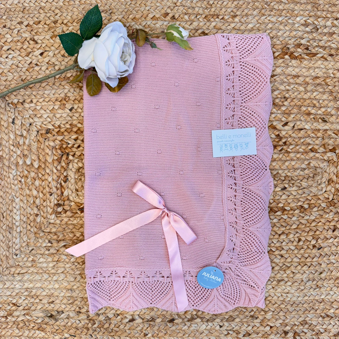 Copertina neonata rosa con fiocco e bordo traforato in maglia

