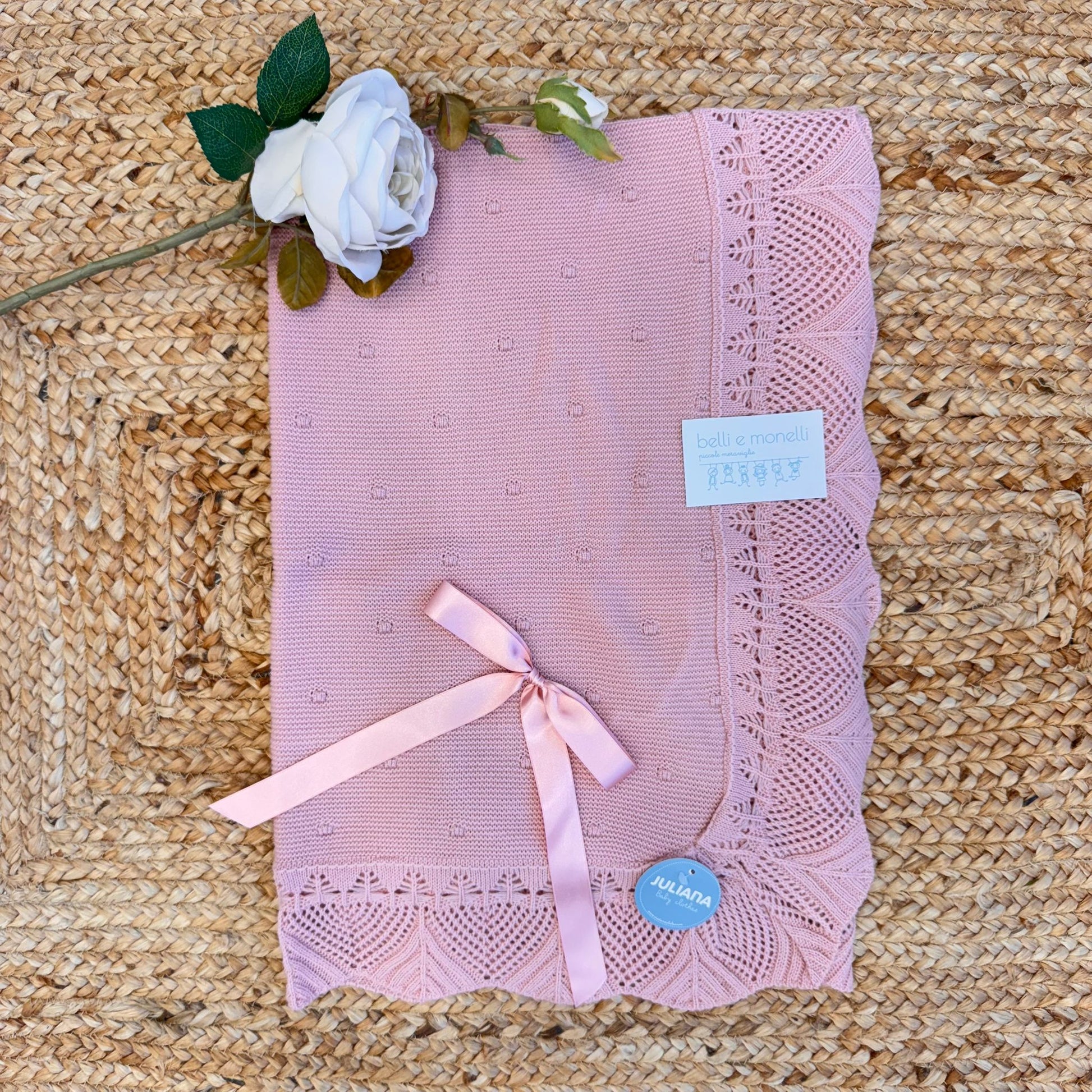 Copertina neonata rosa con fiocco e bordo traforato in maglia

