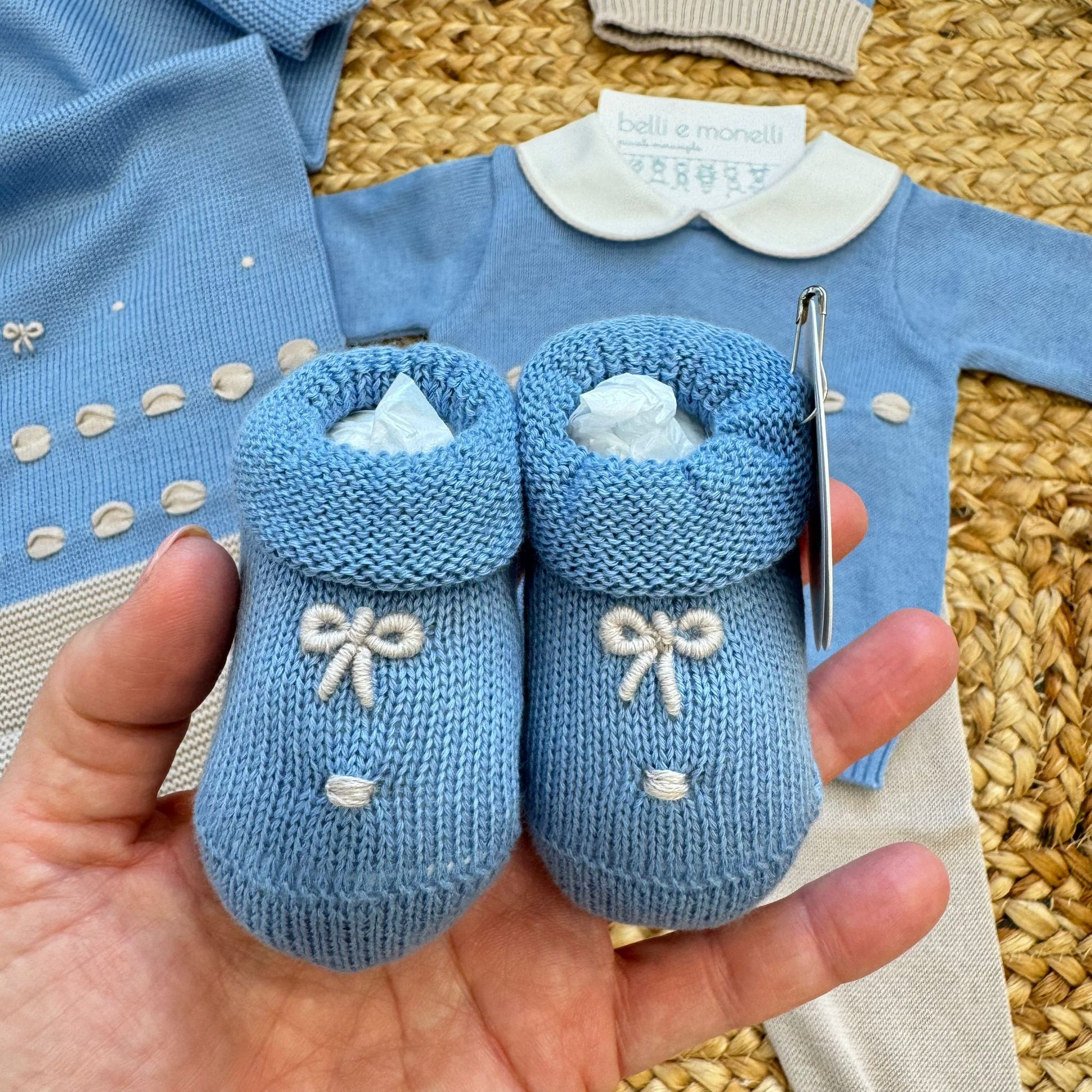 Copertina neonato in 100% filo di cotone con fascia beige e ricami azzurri, coordinata all’uscita clinica