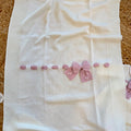 Uscita clinica neonata in pura lana bianca con fiocco rosa e copertina coordinata.