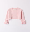 Coprispalle rosa cipria in maglia per bambina con dettagli floreali e bordo smerlato.