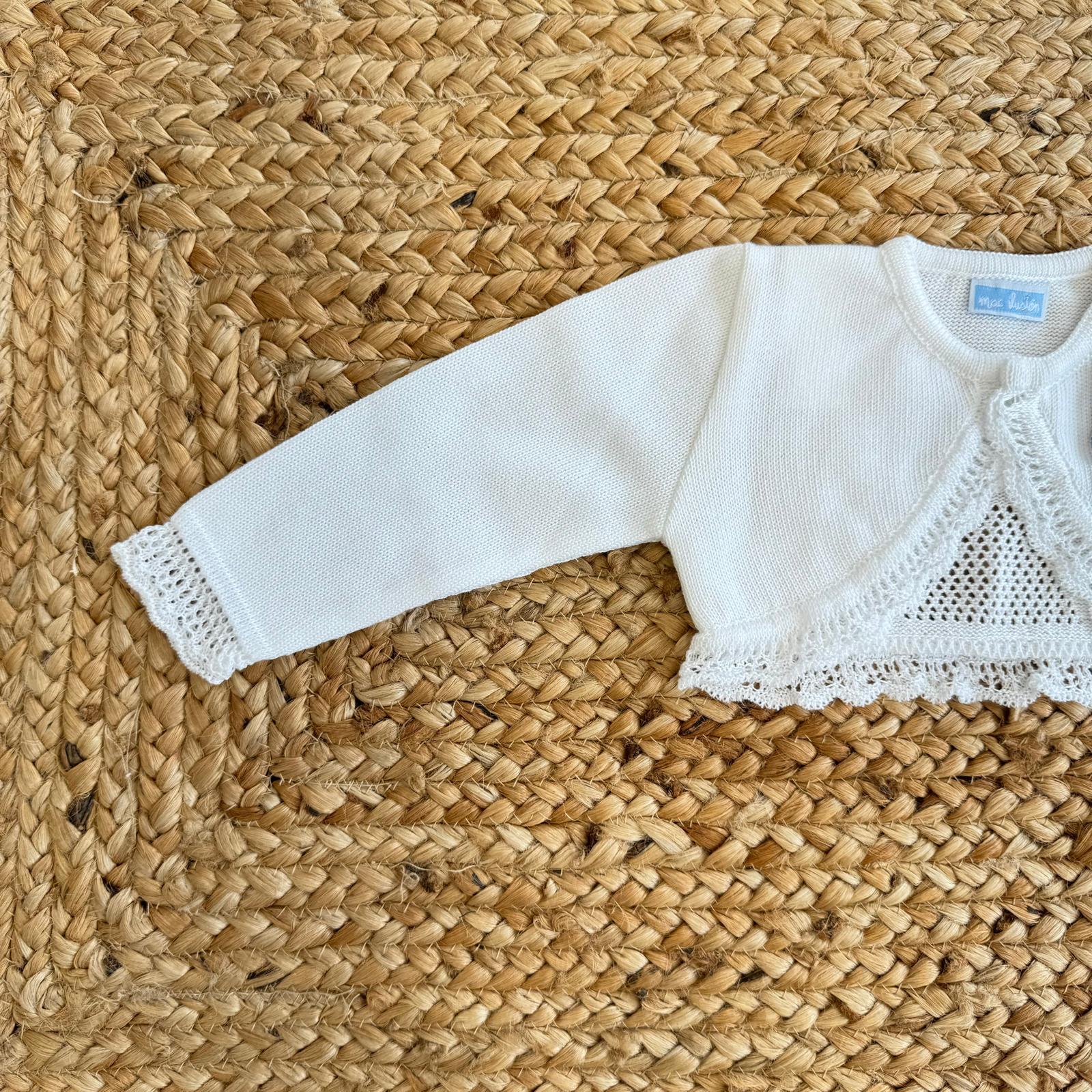 Bolerino bianco per battesimo bambina, con dettagli in pizzo e lavorazione raffinata per un outfit speciale.
