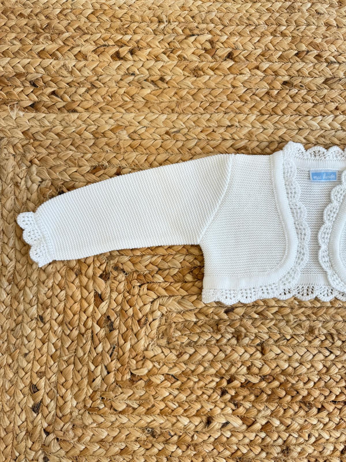Dettaglio manica coprispalle battesimale bianco con lavorazione in pizzo elegante.