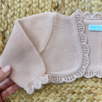 Coprispalle battesimo rosa in maglia con lavorazione traforata, perfetto per neonate.