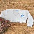 Coprispalle neonata bianco con fiocchi frontali