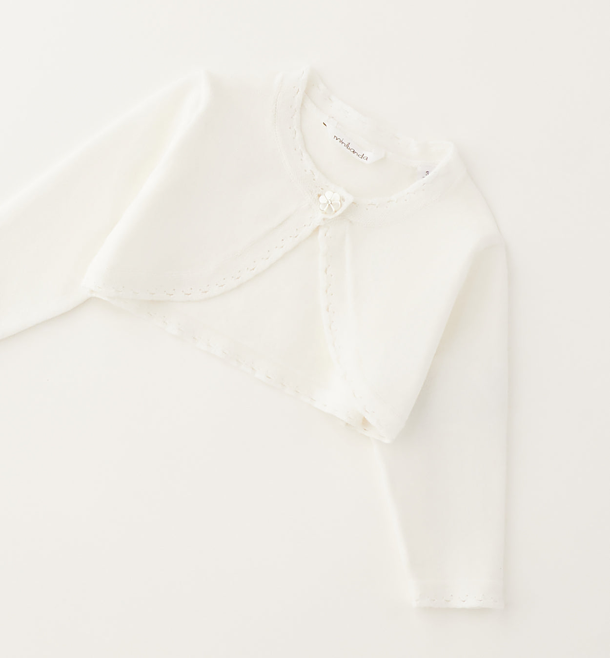 Dettaglio polsino traforato coprispalle neonata bianco