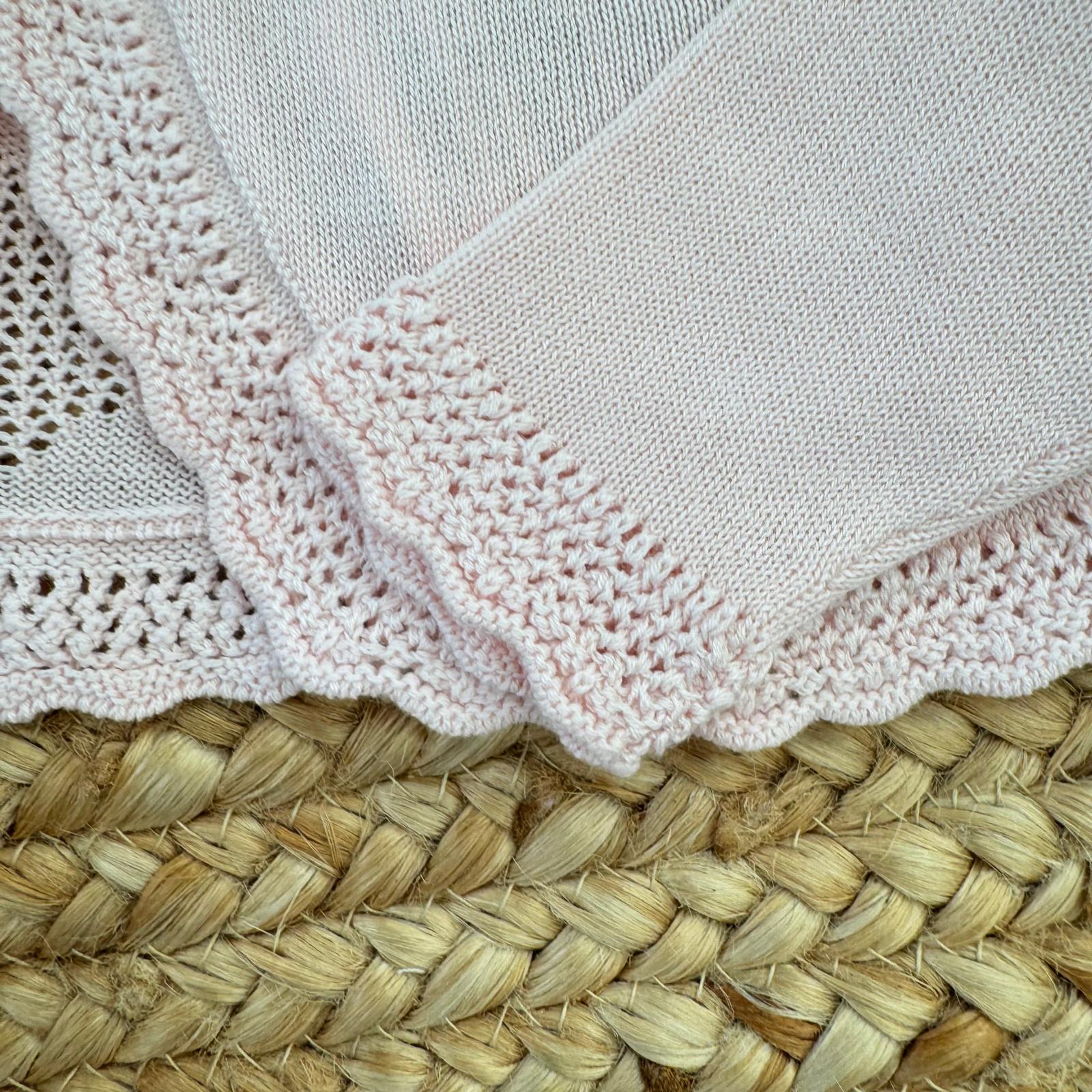 Dettaglio bordo traforato coprispalle rosa neonata