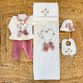 Uscita clinica neonata in ciniglia bianca e rosa con completino ricamato a cuore floreale, fiocco applicato, cappello, bavetta, scarpine, lenzuola coordinate e copertina sfoderabile.