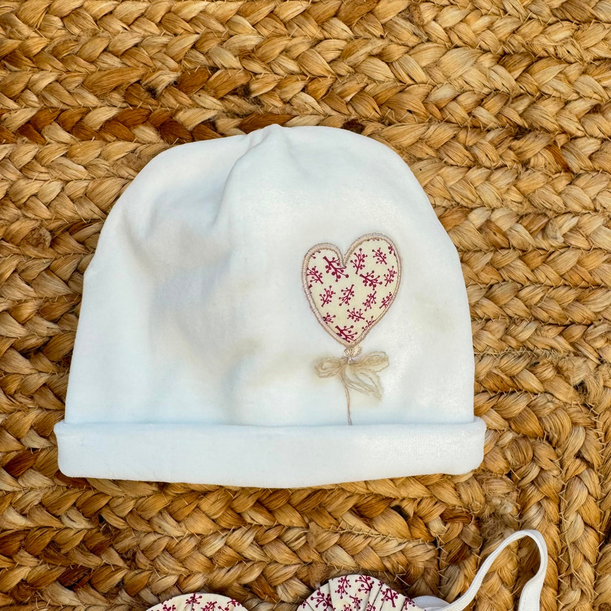 Uscita clinica neonata in ciniglia bianco panna e prugna con tutina, copertina sfoderabile, bavetta, cappellino, scarpine e lenzuolino coordinati.