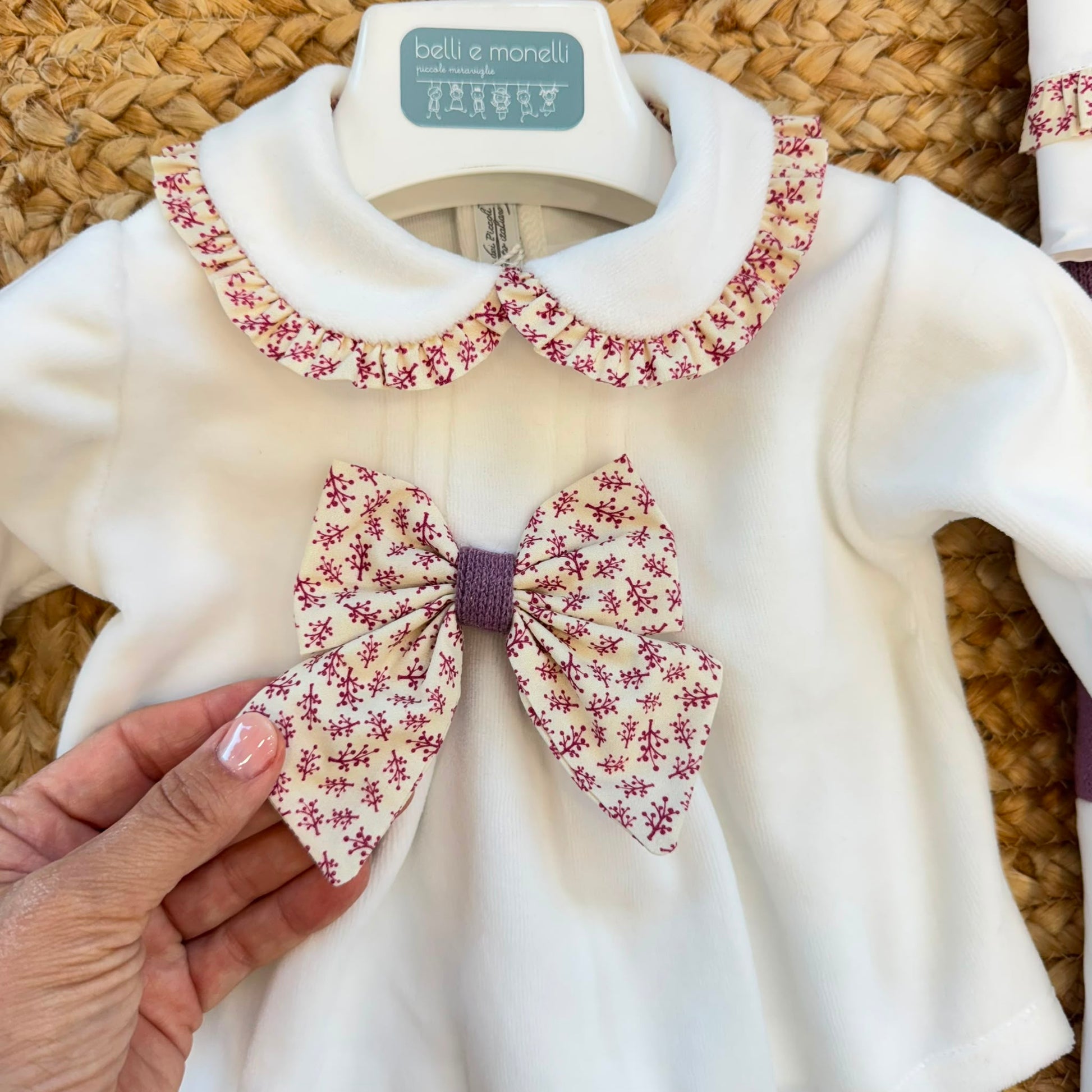 Uscita clinica neonata in ciniglia bianco panna e prugna con tutina, copertina sfoderabile, bavetta, cappellino, scarpine e lenzuolino coordinati.