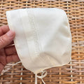 Cuffietta battesimale unisex bianca con ricamo decorativo e laccetti in raso.