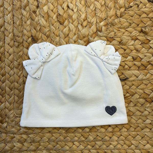 Cuffietta neonata bianca con due fiocchi e cuore ricamato blu.