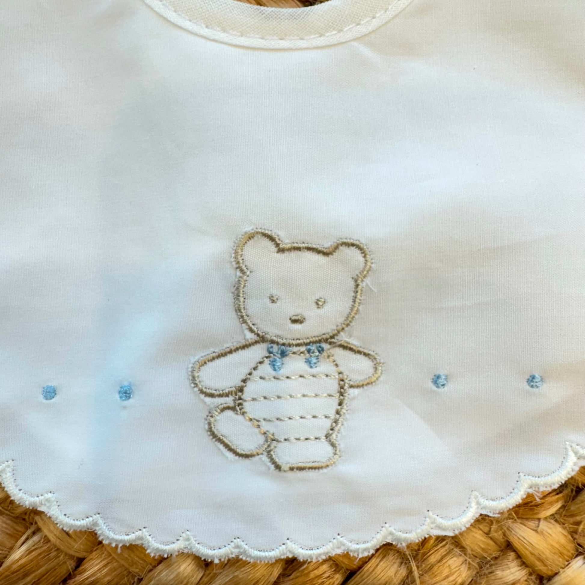 Bavaglino neonato in 100% cotone bianco con ricamo orsetto e bordo smerlato.
