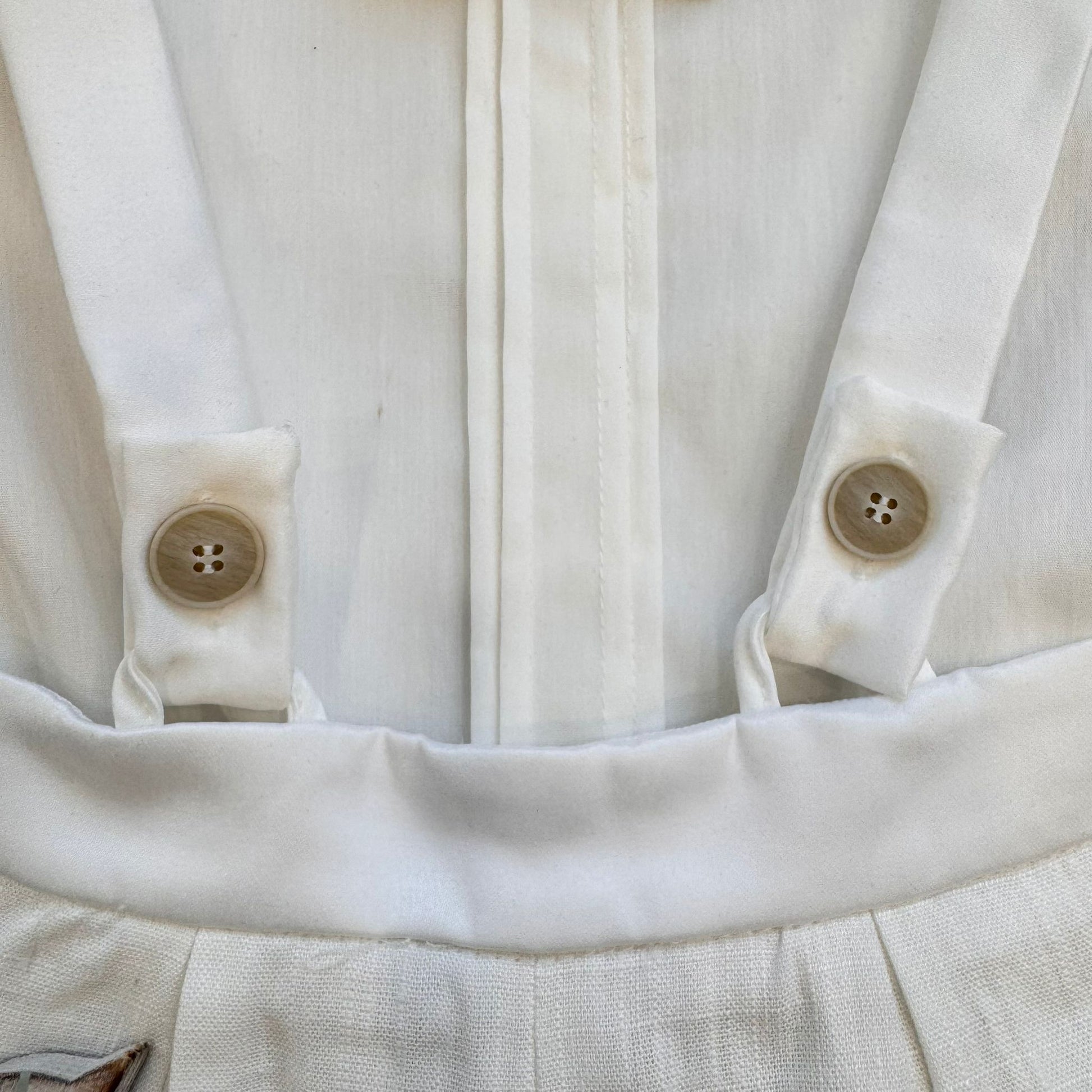 dettaglio body camicia panna con bretelle e bottoni