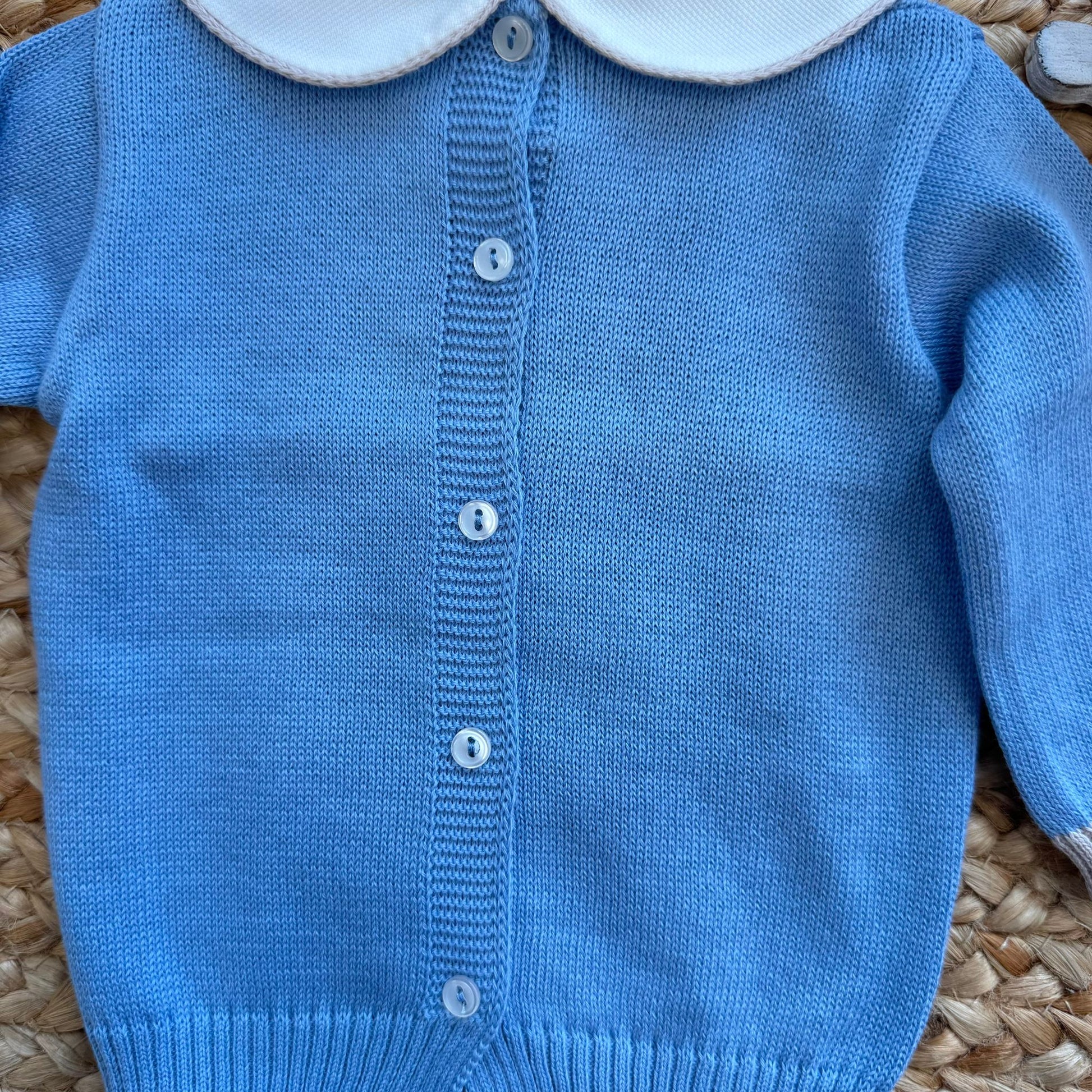 Dettaglio bottoncini decorativi su tutina neonato in cotone