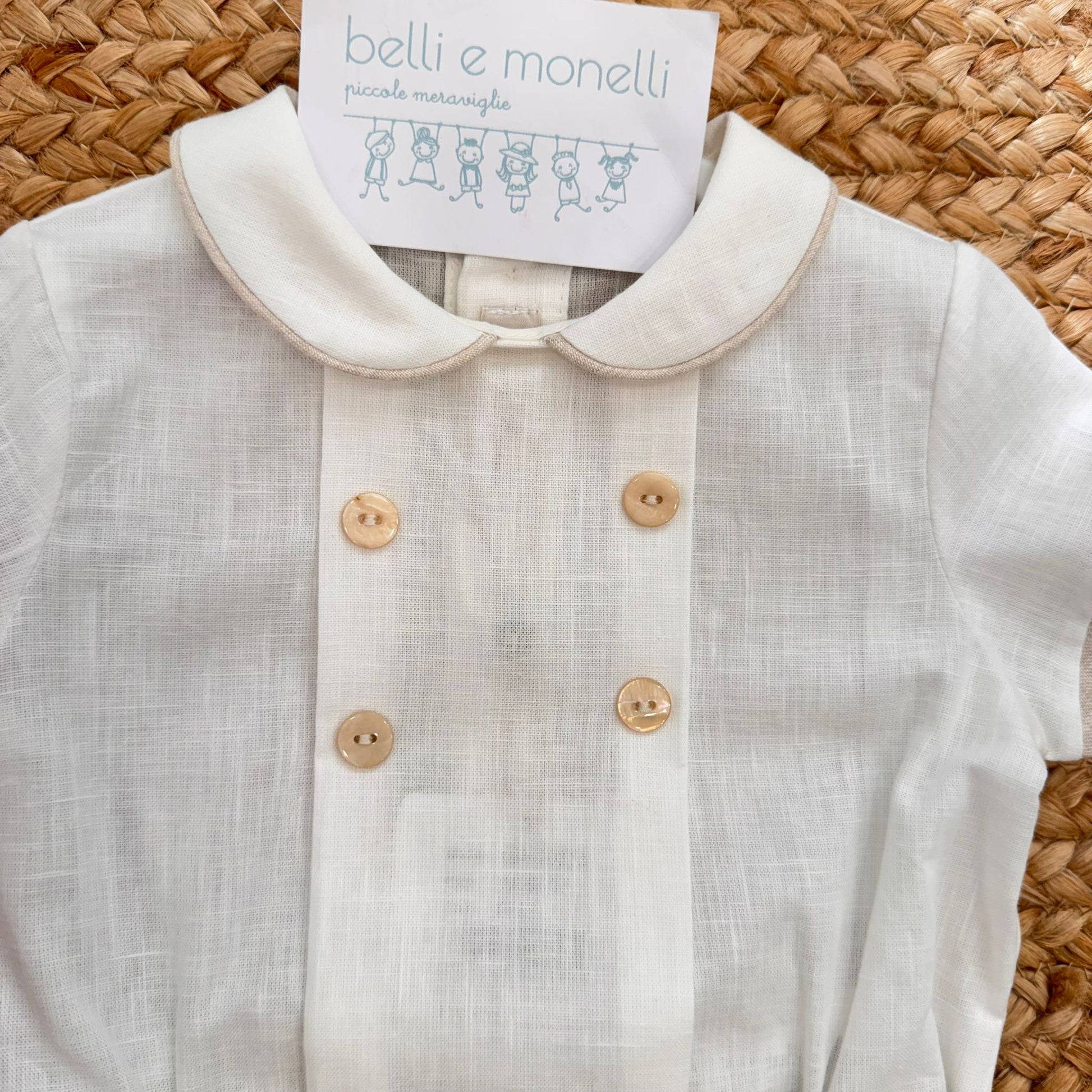 Dettaglio camicia bianca con colletto tondo e bottoni beige completo bimbo