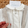 Dettaglio camicia bianca con colletto tondo e bretelle beige completo bimbo