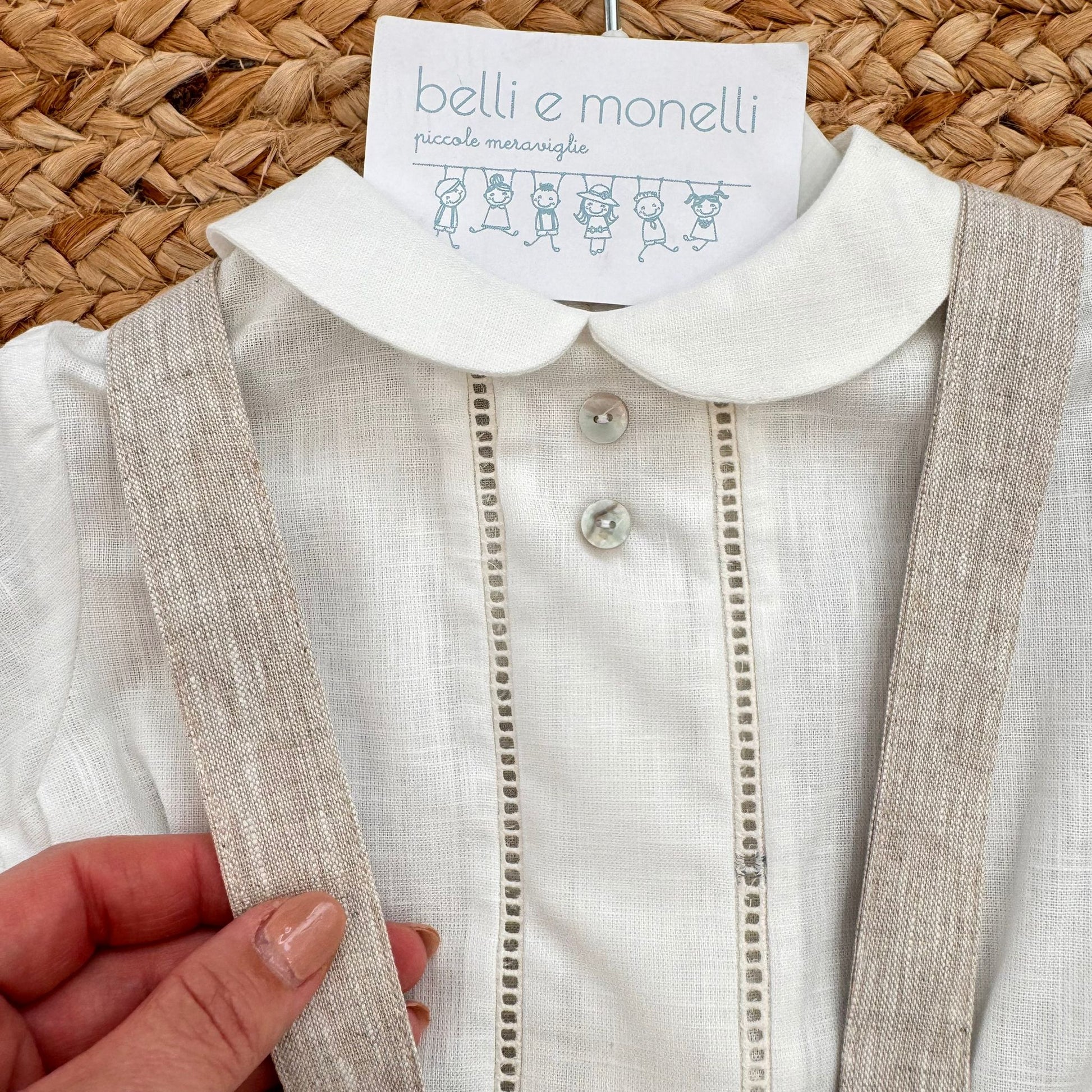 Dettaglio camicia bianca con colletto tondo e bretelle beige completo bimbo